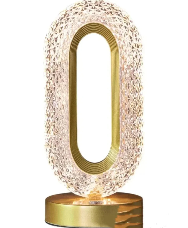 Decorative crystal lamp with textured  o shaped design and gold accents on a gold metal base. Touch sensitive so no switch on it.