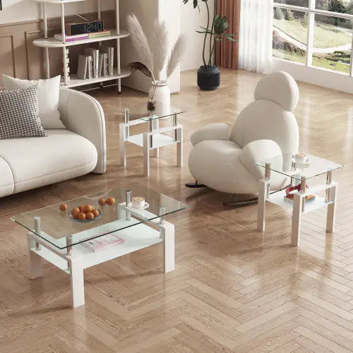 Living or office waiting space with white furniture and bare floor, glass topped coffee table with two matching side tables with wooden legs and shelf underneath the clear glass