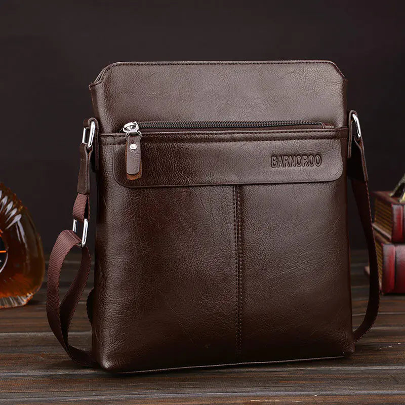 Men's brown leather cross body bag,square with shoulder strap of same material linked to bag with stainless steel hardware. Zippered side pocket has leather pull.