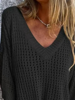 Person wearing a black textured sweater with a necklace