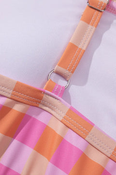 Close-up of a pink and orange checkered bikini top with straps and metal hardware