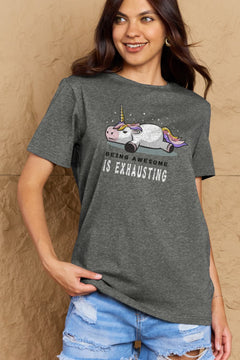Grey Tshirt with a unicorn laying on it's belly with all legs splayed out and the slogan BEING AWESOME IS EXHAUSTING under it. Round neck and short sleeves