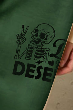 close up of design Green sweatpants of the head and torso of a talking skeleton. Holding up it's right hand with the peace sign and the Slogan says "Have the day you deserve". Cuffed legs and elastic waist with drawstring and side pockets