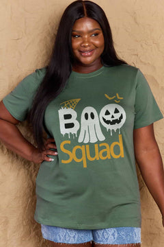 Green round neck tshirt with short sleeves. Hallowee Theme with the word Boo but the first o is a sheet ghost and the second o is a white jack o'lantern and below that is the word Squad in orange. Above the B is an orange spider web and above the pumpkin are three orange flying bat silhouttes