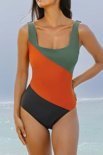Color Block Padded Square Neck One Piece Swimsuit. The bottom band of color comes down across the right hip to the left thigh, the middle and widest band of color comes down from under the arm to middle of the waiste, and the top band of color is a muted green that covers both straps, the neckline and around under the lerft arm. The back is solid black all over.