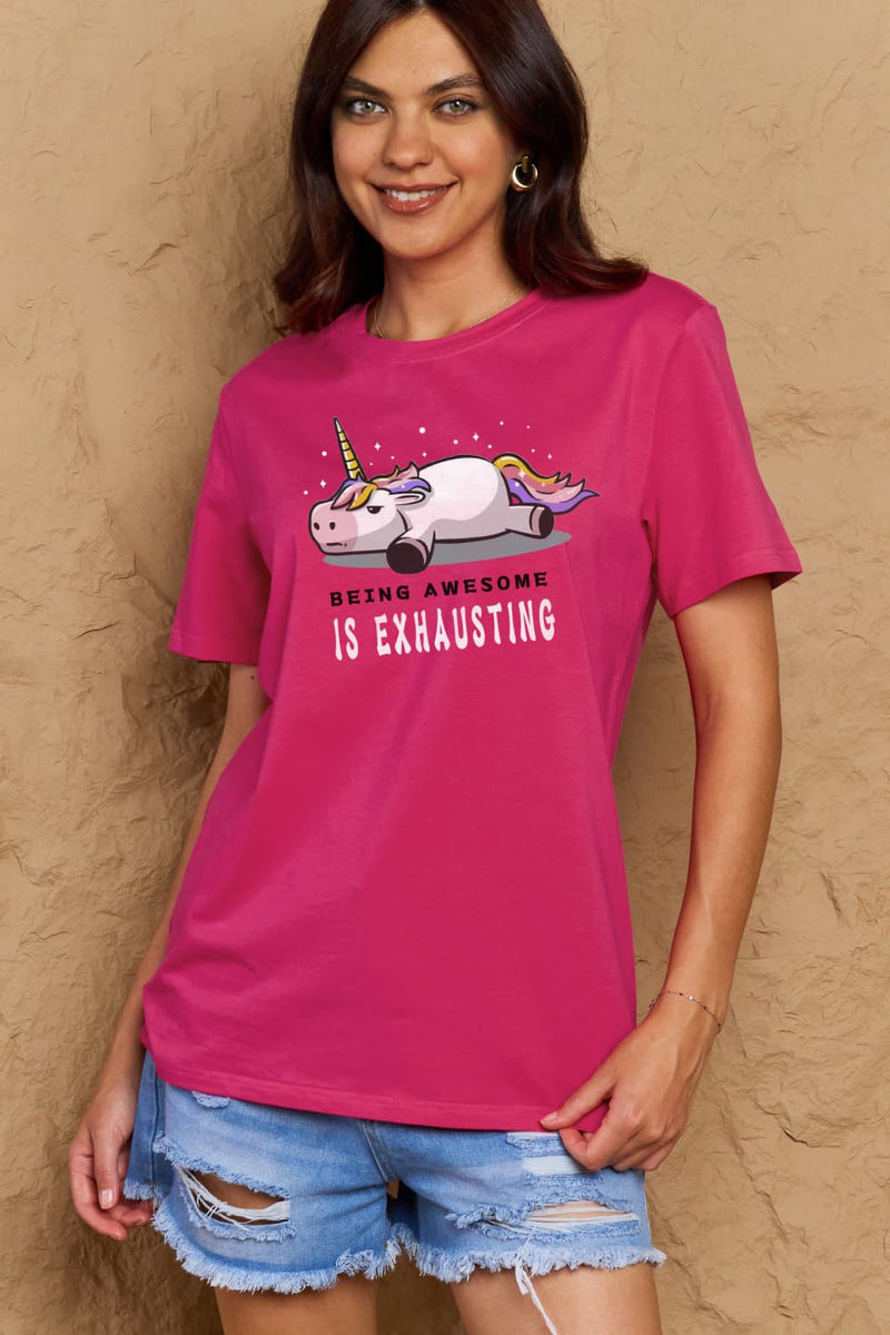 Dark Pink Tshirt with a unicorn laying on it's belly with all legs splayed out and the slogan BEING AWESOME IS EXHAUSTING under it. Round neck and short sleeves