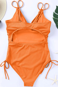 Orange swimsuit with tie straps on a white background