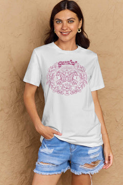 White tshirt with round neck and short sleeves, design is all in pink with Gemini above two long haired twins facing away from each other and encircled by a wreath of flowers and leaves.At the bottom of the design is a circle with Roman numeral Two in it.