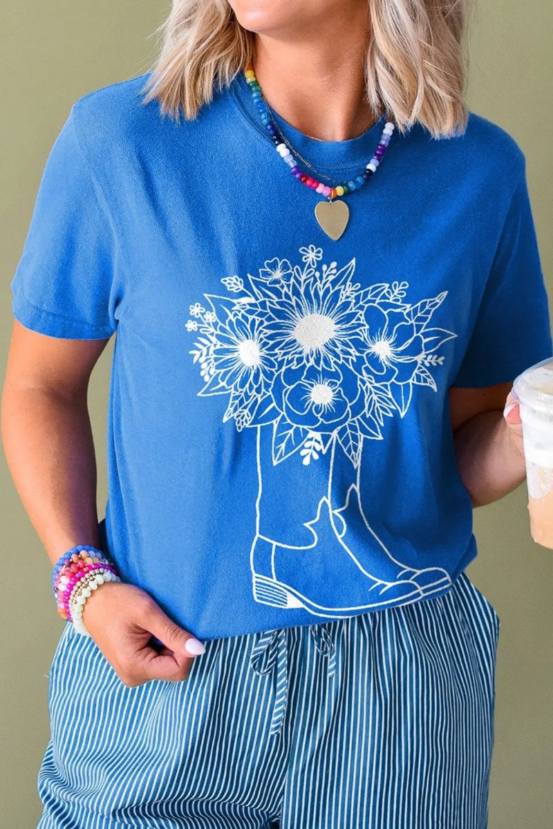 Blue round neck shirt with white drawing of a pair of cowboy boots and a bouquet of flowers coming out of them