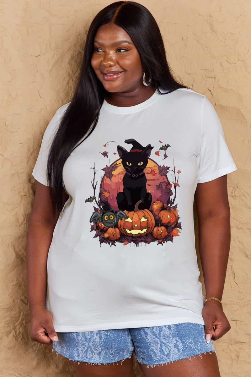 White t-shirt with a Halloween design featuring a black cat, pumpkins, leaves and bats in front of full orange moon.