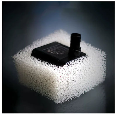 Black pump for a cat water fountain on a block of white foam with a dark background