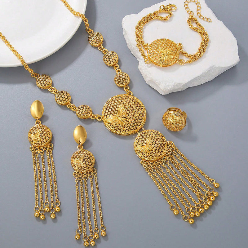 Gold jewelry set including necklace, earrings, and bracelet on a gray surface.
