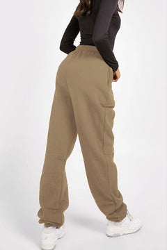 Person wearing beige sweatpants on a white background