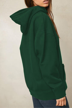 Green hoodie worn by a person on a neutral background