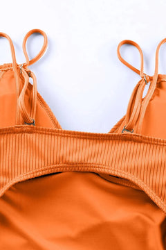 Close-up of an orange bikini set on a light blue background