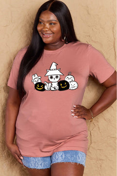 Woman wearing a pink t-shirt with Halloween-themed graphics against a beige background
