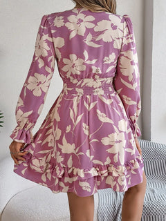 Woman wearing a pink floral dress with long sleeves in a casual setting.