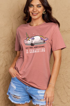Pink Tshirt with a unicorn laying on it's belly with all legs splayed out and the slogan BEING AWESOME IS EXHAUSTING under it. Round neck and short sleeves