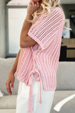 Side view of open work crochet beach cover up in pink short body would not cover suit bottoms