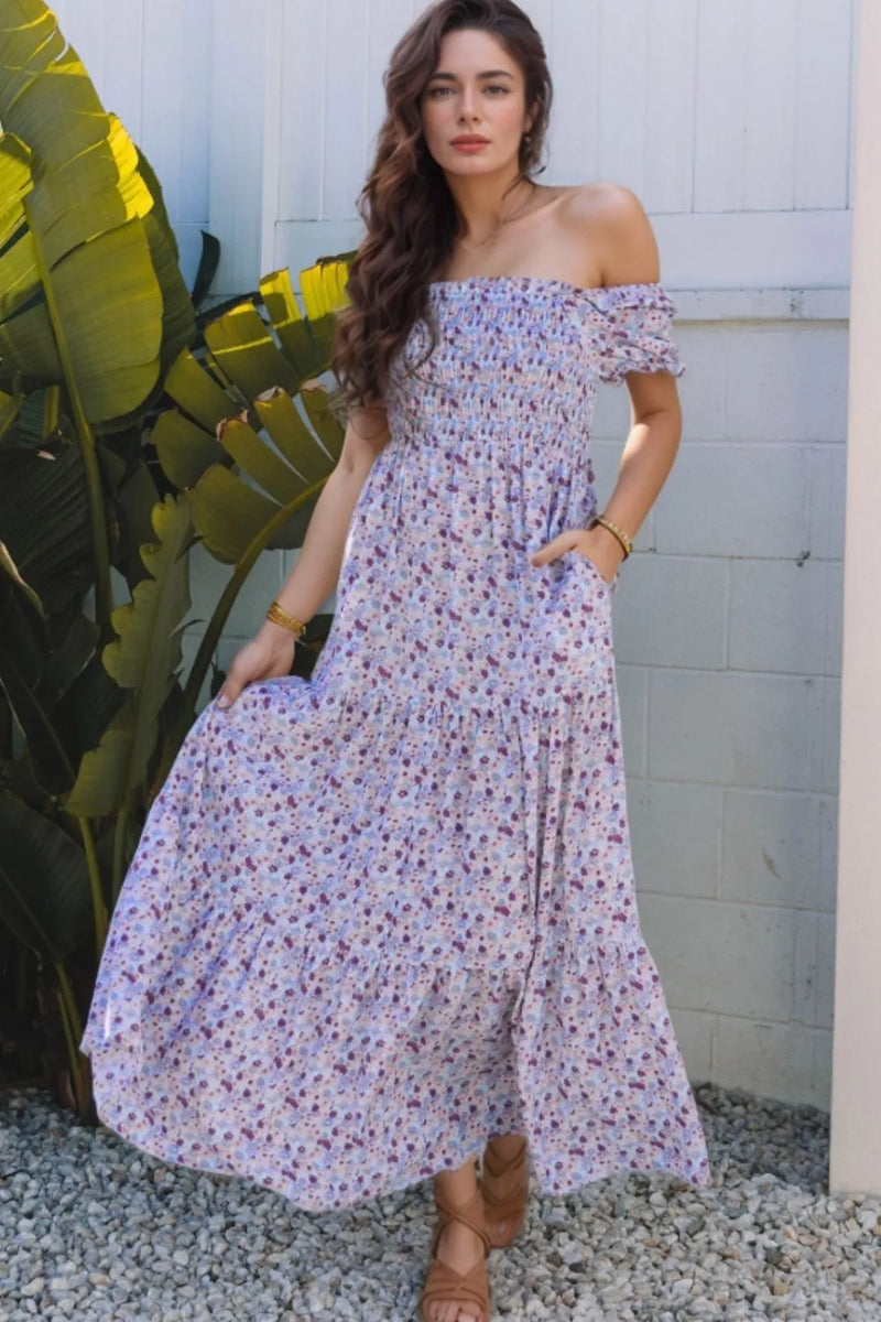 Tiered Floral Shirred High Waist Maxi Dress pale purple background with darker purple smaller flowers all over skirt is very full and has tiered look panels and off the shoulder sleeves. Has side pockets.