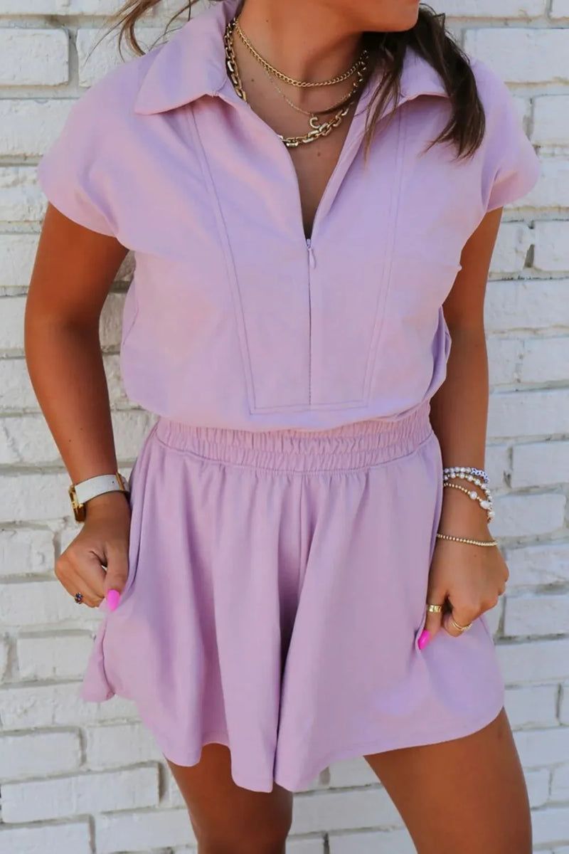 Light purple Romper with very loose fit short bottoms and short sleeved collared top with zipper down the front.