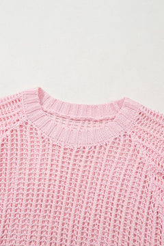 Close-up of a pink knitted beach coverup top on a light gray background