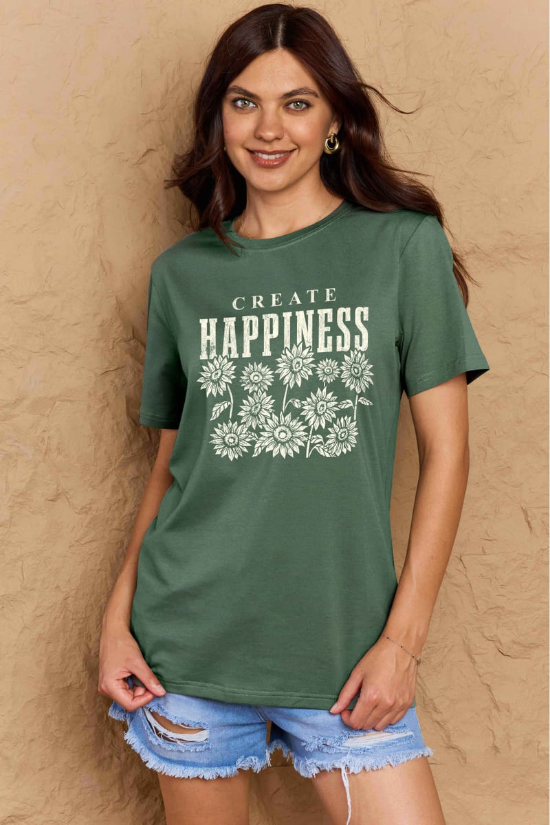 Green Tshirt with round neck and short sleeves, the caption in capital letters says CREATE HAPPINESS, with create being in small letters centered over Happiness. underneath the letters, in white as well, ten flowers arranged in three rows.