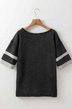 Black t-shirt with white stripes on sleeves hanging on a wooden hanger against a white background