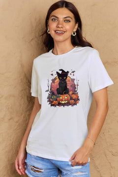 White t-shirt with a Halloween design featuring a black cat, pumpkins, leaves and bats in front of full orange moon.