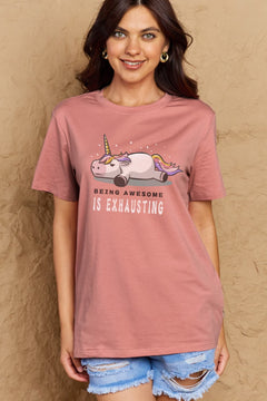 Pink Tshirt with a unicorn laying on it's belly with all legs splayed out and the slogan BEING AWESOME IS EXHAUSTING under it. Round neck and short sleeves