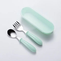 Mint green baby cutlery set with fork and spoon on a light gray background