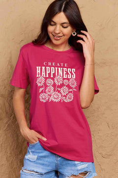 Pink Tshirt with round neck and short sleeves, the caption in capital letters says CREATE HAPPINESS, with create being in small letters centered over Happiness. underneath the letters, in white as well, ten flowers arranged in three rows.