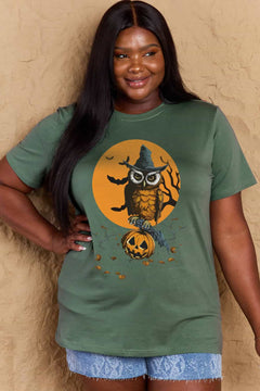 Person wearing a green t-shirt with a Halloween-themed design featuring an owl and pumpkin.