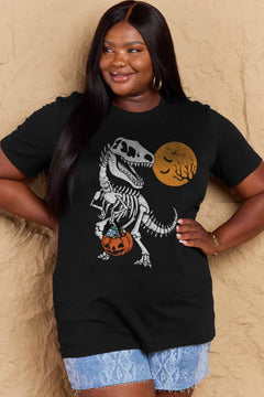 black short sleeved t-shirt with a dinosaur skeleton design on front. Dinosaur is holding a trick or treat jack o'lantern basket with candy in it and looking back at an orange moon with the silhouttes of bats and tree branches in front of it