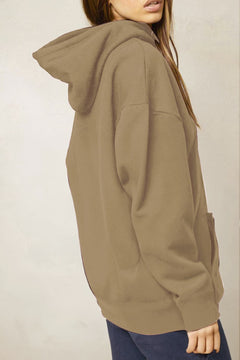 Person wearing a brown hoodie against a plain background