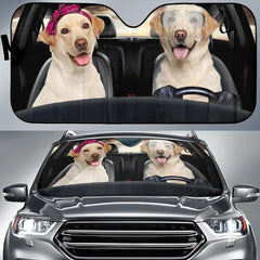 Car sunshade with a design of two dogs in a car, one wearing a pink bandana and the other with googly eyes.