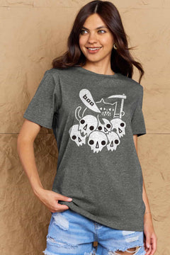 Grey  tshirt round neck with short sleeves and Halloween design of 6 white skulls below and outline of a cat saying boo and holding a scythe.