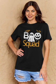 Black round neck tshirt with short sleeves. Hallowee Theme with the word Boo but the first o is a sheet ghost and the second o is a white jack o'lantern and below that is the word Squad in orange. Above the B is an orange spider web and above the pumpkin are three orange flying bat silhouttes