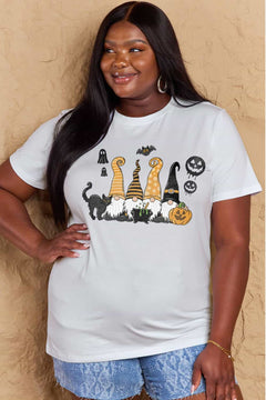 White t-shirt with Halloween-themed graphics. Four gnomes sitting behind a caldron with green brew bubbling out, a black cat with arched back on the right and a grinning jack o'lantern on the left with black 'sheet' ghosts, a bat and two black jack o' lantern silhouttes hovering above. Each gnome has a long pointy hat in either orange, black, or a combination of the two. The gnome on the left has a witch hat.