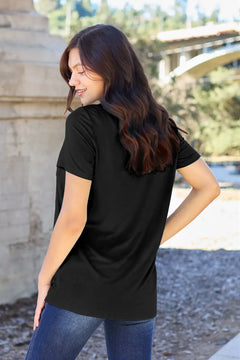 Woman wearing a black t-shirt outdoors with blurred background