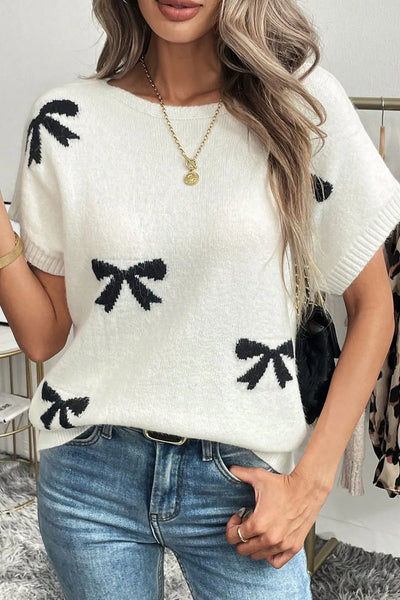 Fuzzy white sweater with Black bows printed on it, short sleeves and boat neck