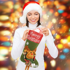 Woman wearing a Santa hat holding a Christmas stocking with a festive background