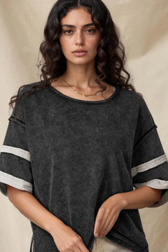 Faded look black tshirt with dropped shoulders and sleeves with two bands of trim in white and scooped neck almost make it look like a football jersey. Exposed seams and long body