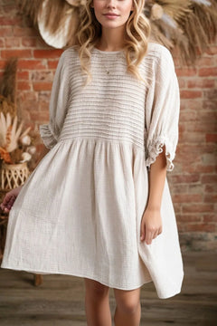 White/beige dress with ruffled three quarter sleeves. Full skirt and horizontal ribbed design across the bodice.