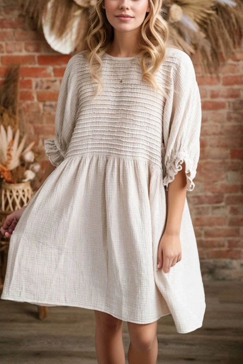 White/beige dress with ruffled three quarter sleeves. Full skirt and horizontal ribbed design across the bodice.