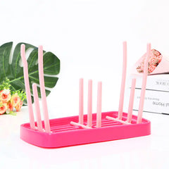 Pink baby dish drying rack on a white background