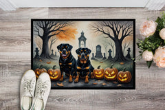 Halloween-themed doormat with two Rottweilers, pumpkins, and a graveyard scene on a wooden floor.