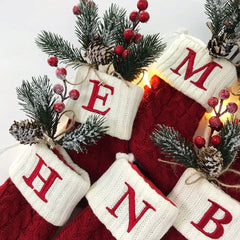 Red and white Christmas stockings with monogram letters on a white background