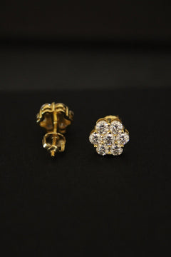 Gold and moissanite earrings on a black background