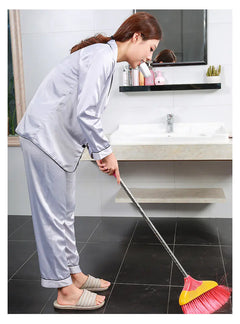 Woman cleaning a bathroom with a broom and dustpan. while using  Ultrasonic Automatic Mouth with Toothbrush! In white